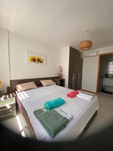 a bedroom with a large bed with two towels on it at Apartament Piratininga in Niterói