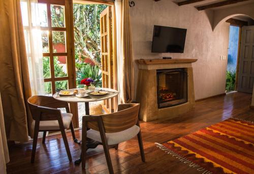 a living room with a table and a fireplace at Guayaba Inn Boutique Hotel in San Cristóbal de Las Casas