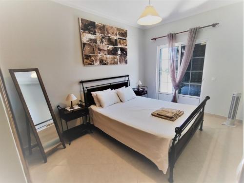 ein Schlafzimmer mit einem großen Bett und einem Spiegel in der Unterkunft Vivenda para férias (Algarve) in Manta Rota