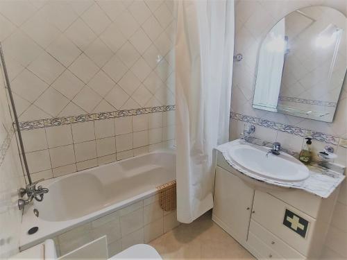 ein Badezimmer mit einem Waschbecken, einer Badewanne und einem WC in der Unterkunft Vivenda para férias (Algarve) in Manta Rota