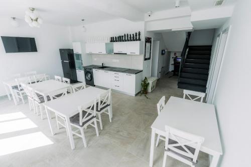 a dining room with white tables and white chairs at Catharsis House - self check in and self checkout in Oradea