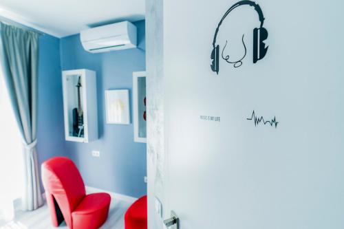 a room with a red chair and blue walls at Catharsis House - self check in and self checkout in Oradea