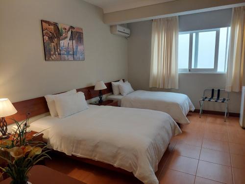 a hotel room with two beds and a window at Lima Wasi Hotel Miraflores in Lima