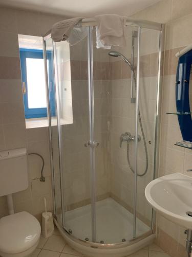 a bathroom with a shower with a toilet and a sink at House Rozalia in Susak