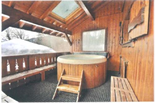 eine Holzhütte mit einer Sauna und einem Holzstuhl in der Unterkunft Chalet Esprit in Morillon