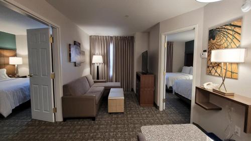 een hotelkamer met een bank en een bed bij Staybridge Suites - Calgary Airport, an IHG Hotel in Calgary