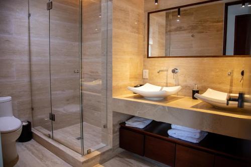 ein Bad mit 2 Waschbecken und einer Dusche in der Unterkunft Kiin Tulum, Luxury Suites in Tulum