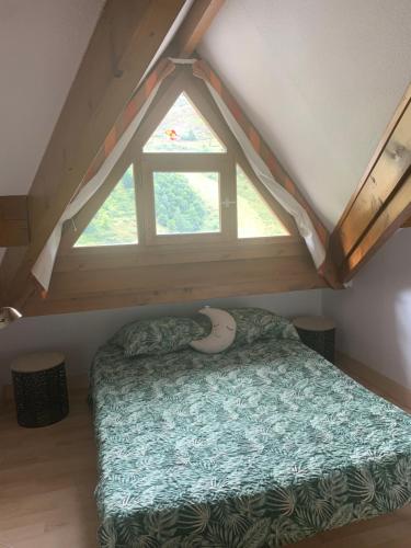 a bed in a room with a large window at Pied des pistes, pleine nature in Ustou