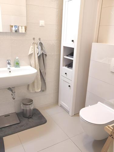 a white bathroom with a sink and a toilet at Izzy - 5 min walk from the main square in Zagreb