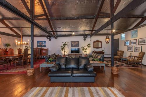 a living room with a leather couch and a table at BH Studios Hotel Brás in Sao Paulo