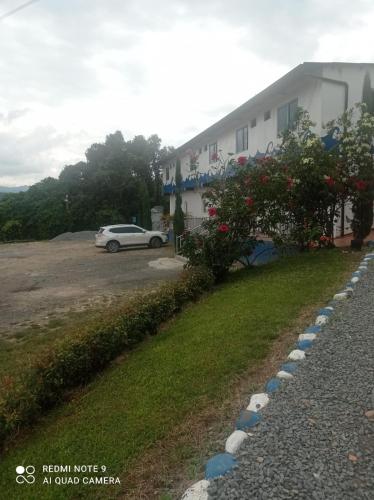 a building with a car parked in a parking lot at Hotel Las Palmas de Puente Nacional in Puente Nacional