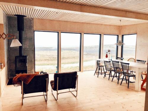 a living room with a table and chairs with a view of the ocean at Beautiful cottage with Mountain View in Fludir