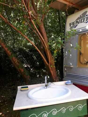 - un lavabo en face d'une caravane de camping dans l'établissement L'Ermitage au sein d'un jardin forêt près de l'océan, à Mimizan