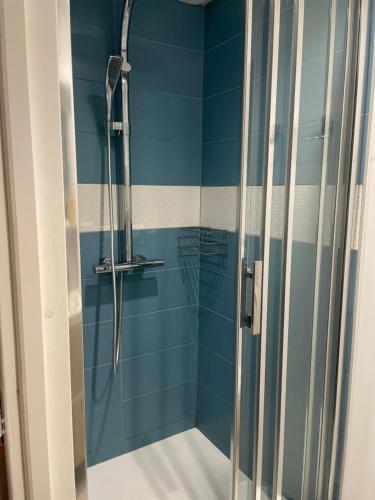 Łazienka z prysznicem wyłożona jest niebieskimi kafelkami. w obiekcie chez Marjorie w Annecy