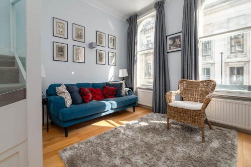 a living room with a blue couch and a chair at GuestReady - Stunning Covent Garden 2BR Duplex in London