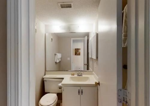 ein Badezimmer mit einem WC, einem Waschbecken und einem Spiegel in der Unterkunft A Place At The Beach by TO in Atlantic Beach