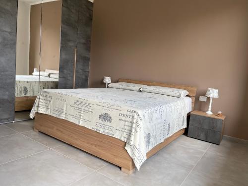Villa Fiorita في San Maurizio Canavese: غرفة نوم مع سرير مع لحاف أبيض ومرآة
