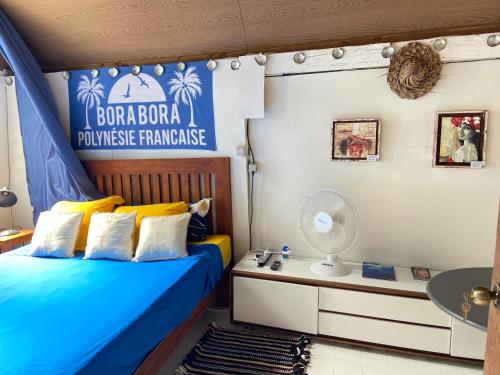 a bedroom with a bed and a desk with a fan at ONLY YOU MOTU in Bora Bora