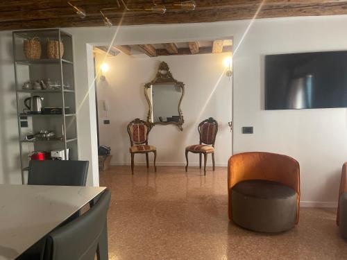 een woonkamer met 2 stoelen en een spiegel bij Ca' ai Sospiri in Venetië