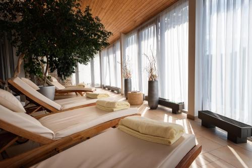 a room with a bunch of beds and windows at Spa hotel Lanterna in Velké Karlovice