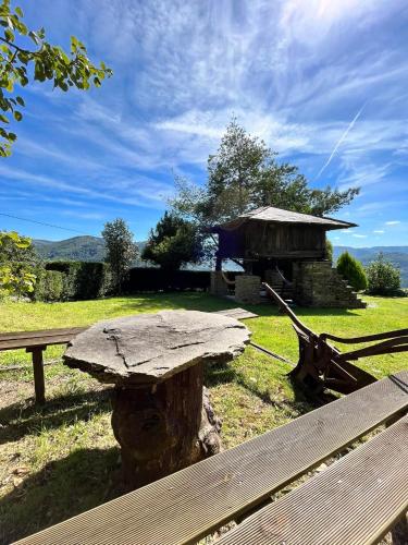 a picnic table and a bench in a field at Complejo Rural Lar de Vies in A Pontenova