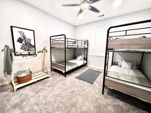 a room with three bunk beds and a ceiling fan at San Diego Luxury Oasis in Spring Valley