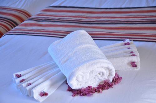 a white towel and chopsticks on a bed at Hotel Al Akha in Sidi Harazem