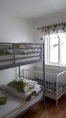 Etagenbett mit Kinderbett in einem Zimmer mit Fenster in der Unterkunft Brúnalaug Guesthouse - Holiday Home in Eyjafjaroarsveit