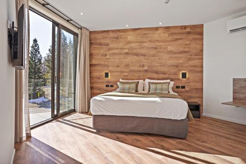 a bedroom with a large bed and a large window at Grand Suites Lake Tekapo in Lake Tekapo