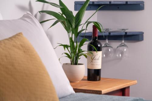 a bottle of wine on a table next to a plant at Mad River Lodge in Waitsfield