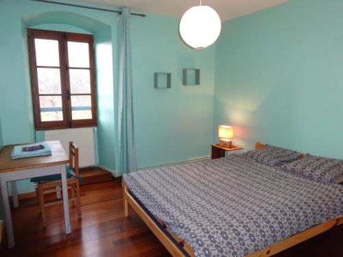 a bedroom with a bed and a table and a window at Gîte Clé des Champs in Saint-Laurent-en-Royans