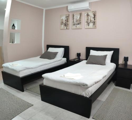 2 letti in una camera con pareti bianche di Airport Apartment AIR a Surčin