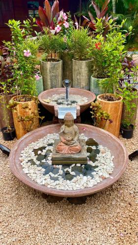 a statue of a woman sitting in a fountain at LA CASE BOIS CRÉOLE in Albion