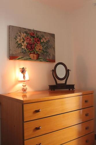 a dresser with a mirror and a lamp on top of it at Casetta Mimì in San Pio delle Camere