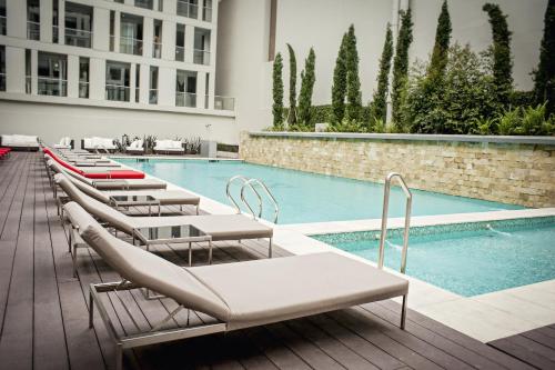 a row of lounge chairs next to a swimming pool at CasaSur Bellini in Buenos Aires