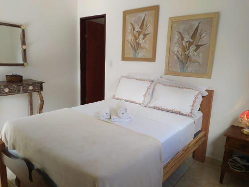 una camera da letto con un letto con due tazze sopra di Casa Próximo do Centro a Parati