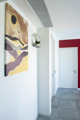 a hallway with a painting on the wall and a door at B&B Lough in Colà di Lazise