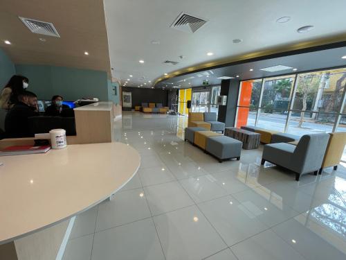 a lobby with a table and chairs in a building at Diego de Almagro Providencia Express in Santiago
