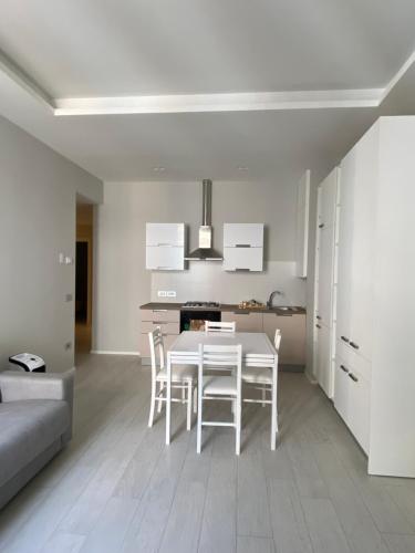 a kitchen and dining room with a white table and chairs at CASA DANTE: Oneglia Centro-Marina-Spiagge (3 min) in Imperia