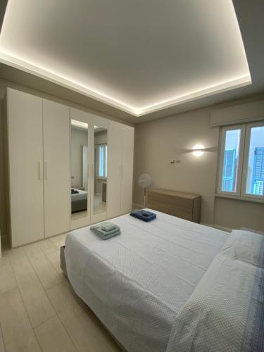 CASA DANTE: Oneglia Centro-Marina-Spiagge (3 min) في إمبيريا: غرفة نوم بسرير ابيض كبير عليها مناشف