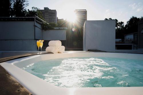 a hot tub with towels and a glass of water at Suites Obelisk in Mexico City