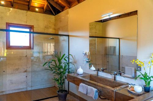 uma casa de banho com um grande lavatório e um chuveiro em Atiaia Jungle River Retreat em Visconde de Mauá