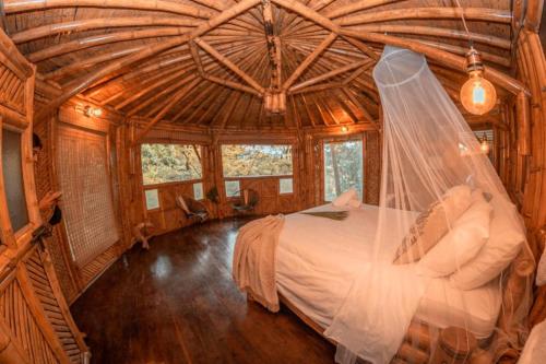 a bedroom with a bed with a veil on it at Ecohotel Tierra de Agua in Cocorná