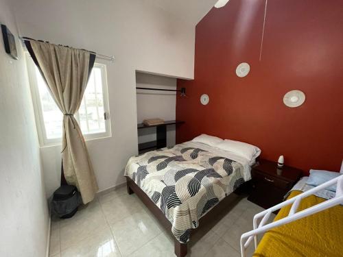 a small bedroom with a bed and a window at Sensity Home Preciosa y espaciosa casa todos los servicios 5 min del CIS in Tehuacán