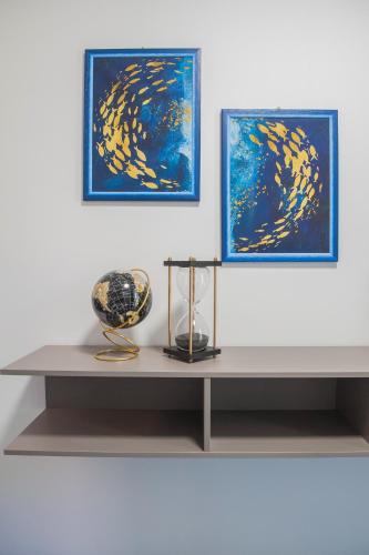 a table with two paintings and a vase on it at B&B Lough in Colà di Lazise