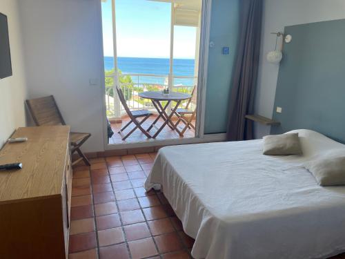 a bedroom with a bed and a view of the ocean at Appartement piscine et vue mer in Tartane