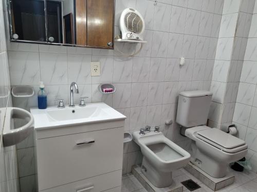 biała łazienka z umywalką i toaletą w obiekcie La casa de Chiqui w mieście Mendoza