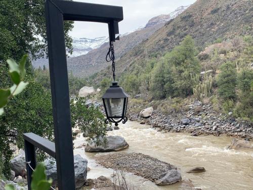 ein Licht, das von einer Stange an einem Fluss hängt in der Unterkunft BORDEMAIPO LODGE in San José de Maipo