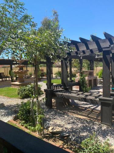 a park with benches and a wooden pergola at Estancita Elena in Valle de Guadalupe