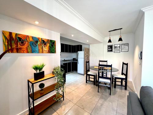 Lumiere Apartments - Departamento en Complejo Residencial في ميندوزا: غرفة معيشة وغرفة طعام مع طاولة ومطبخ